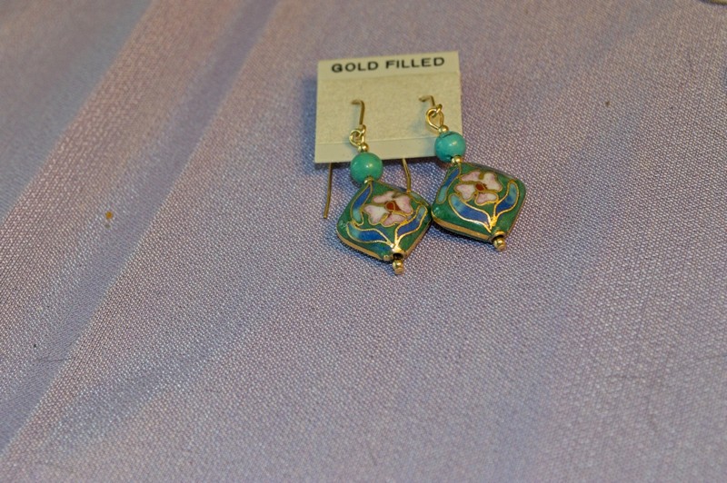 a diamond-shaped cloisonne drop earring set with a green background