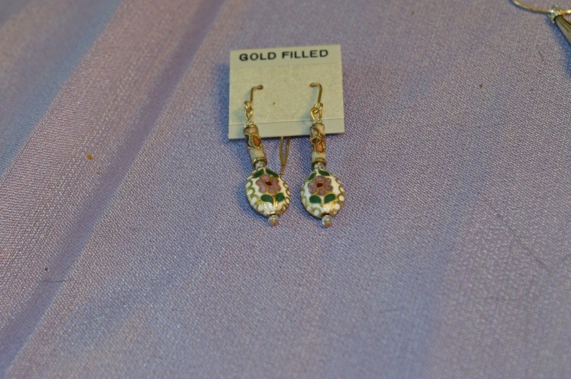 drop earrings featuring both an oval and a tube bead of cloisonne with a white background.