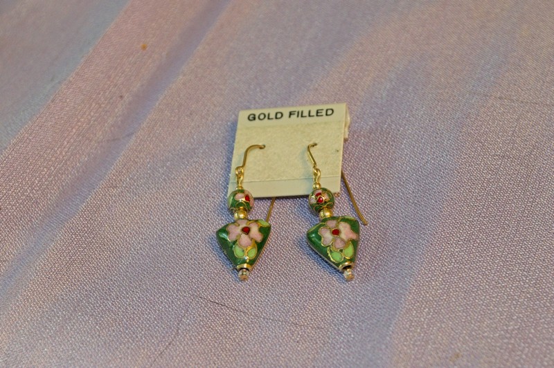 these triangular shaped cloisonne beads have a dark green background that shows off the floral image particularly well