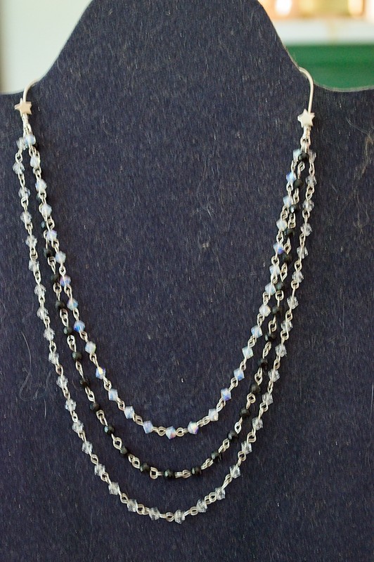 necklace that begins in the back with round sterling silver chain and transitions
to a three-strand design featuring czech crystal beads and round faceted black onyx beads